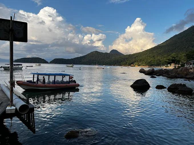 Enseada de Araçatiba ao entardecer com a Flexboat ancorada em águas calmas